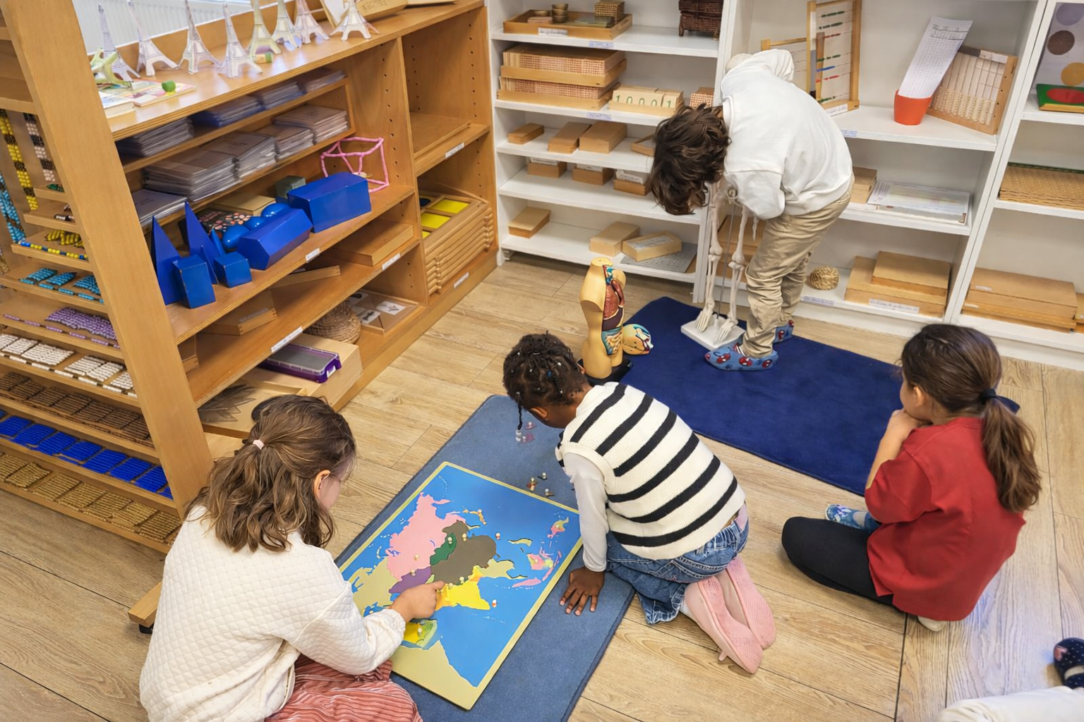 École Montessori à Rueil-Malmaison – élèves en classe élémentaire travaillant avec du matériel éducatif et une carte du monde